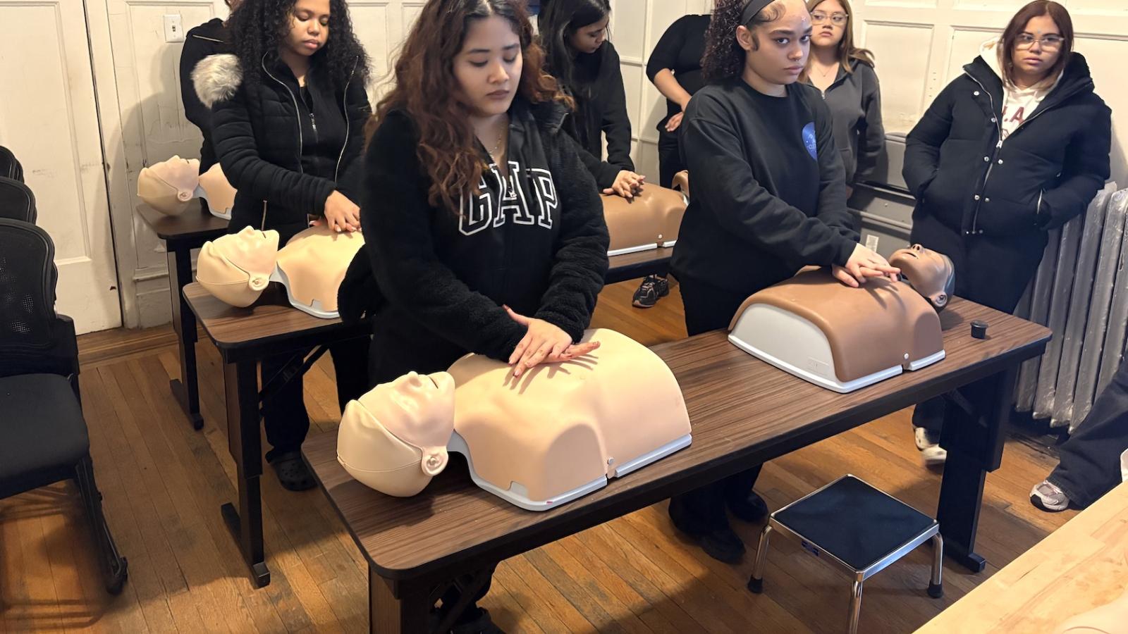 Students practice CPR on dummies