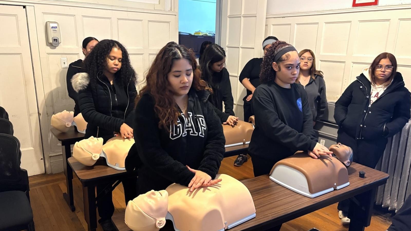 Students practice CPR on dummies