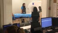 Medical students scan a cadaver in a CT room.