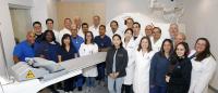 Group of physicians and techs at a PET/CT scanner